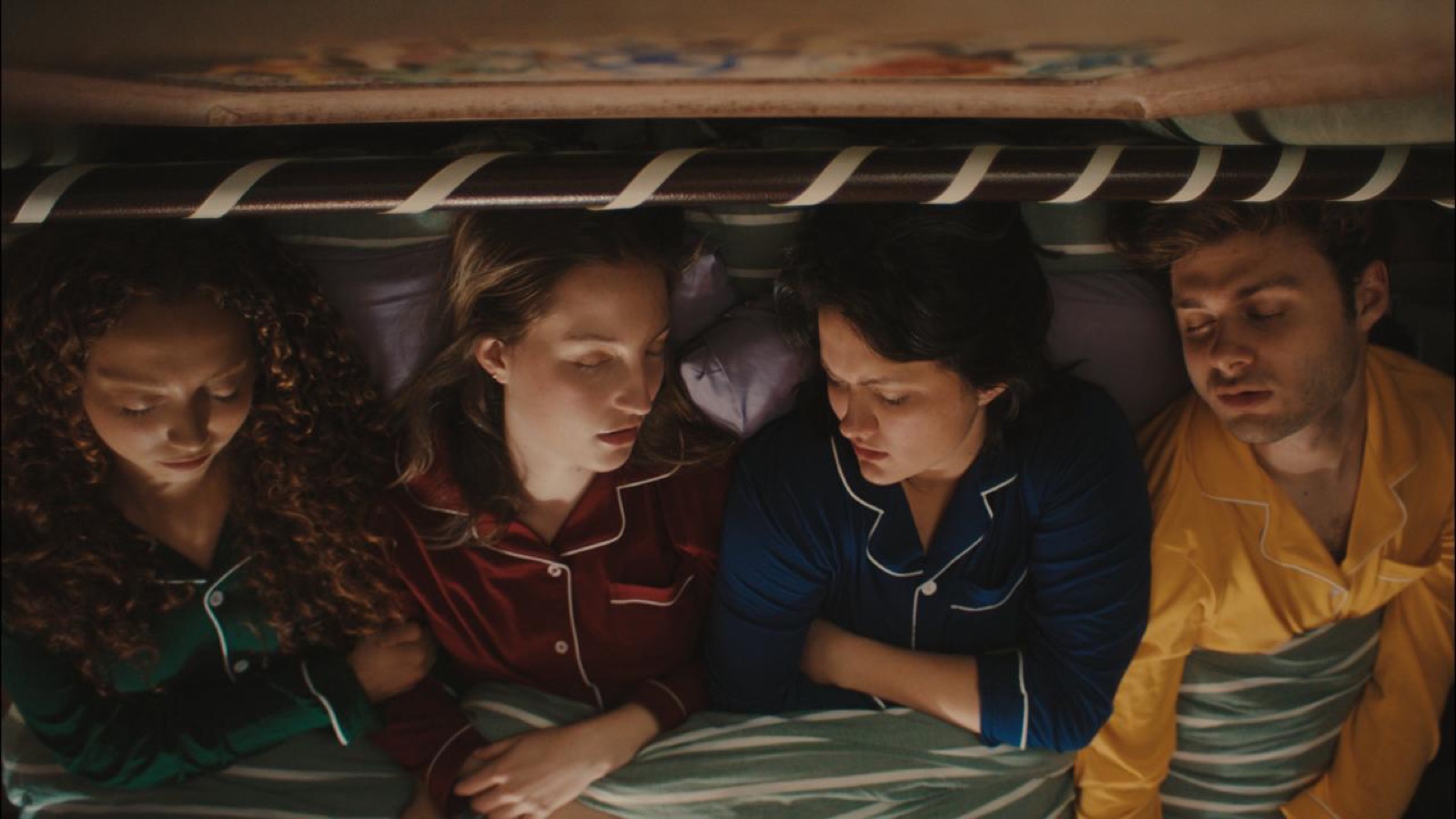 The four friends asleep side by side under one bed