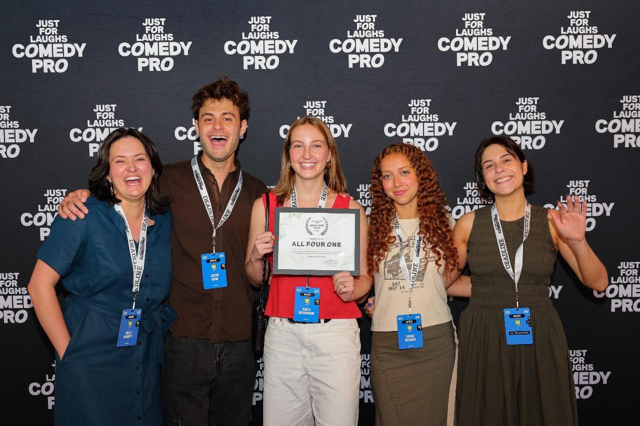 Skip Skip and the All Four One team holding the Grand Jury Prize certificate in front of the Just For Laughs ComedyPro backdrop in Montreal