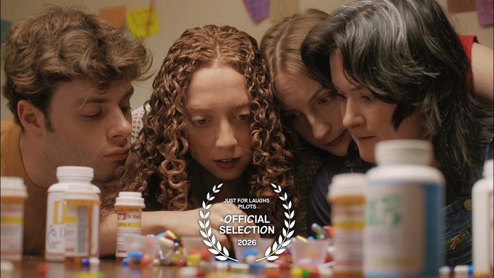 Still from All Four One: the four friends huddled over a table of pill bottles, with the Just For Laughs Pilots Official Selection laurel